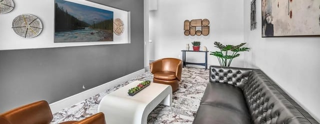 Leather couches coffee table and wall art living room at Haven At Elgin in Houston Student Accommodation