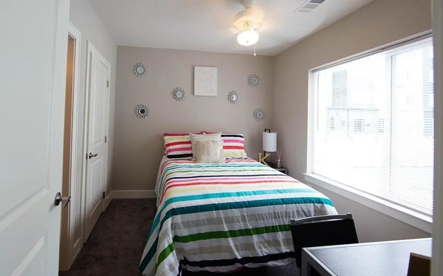 Colorful striped bedding on bed with lamps bedroom at Park Place Columbia in Columbia Student Accommodation