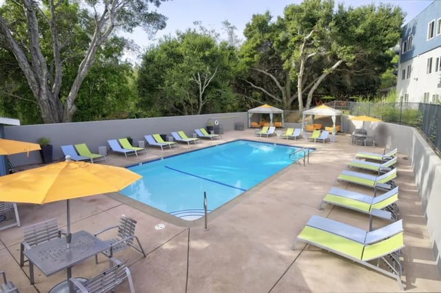 Pool lounge chairs and umbrellas outdoor recreation area at Mustang Village Apartments in San Luis Obispo Student Accommodation