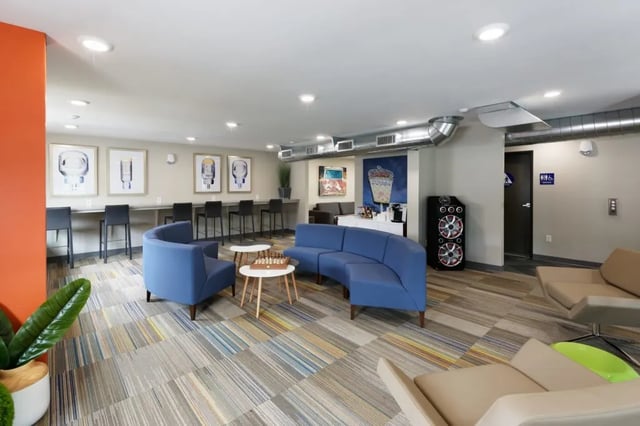 Blue couches study area with chairs and tables living room at Mustang Village Apartments in San Luis Obispo Student Accommodation
