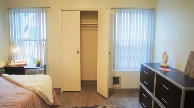 Bed desk closet dresser window bedroom at Mustang Village Apartments in San Luis Obispo Student Accommodation