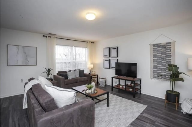 Two sofas coffee table TV rug living room at State College Collective Apartments in State College Student Accommodation