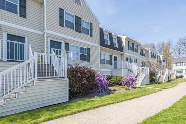 Townhouses with white stairs and purple flowers exterior at State College Collective Apartments in State College Student Accommodation
