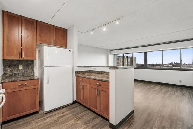 Wooden cabinets white refrigerator kitchen island kitchen at Chateau Student Housing Co-op in Minneapolis Student Accommodation