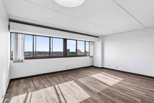 Empty room with large windows and wood floor living room at Chateau Student Housing Co-op in Minneapolis Student Accommodation