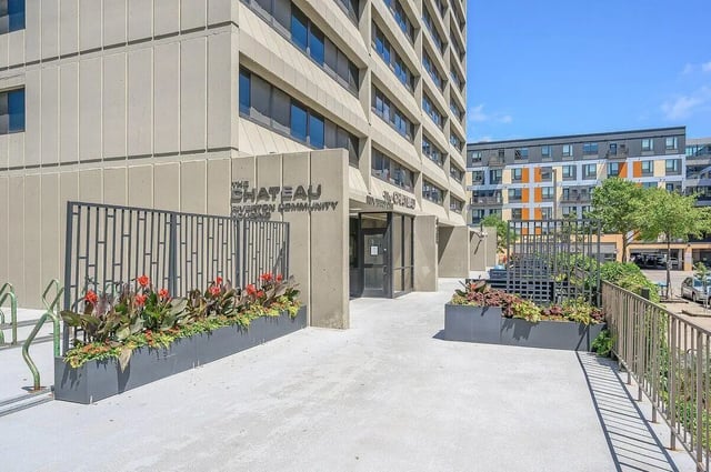 Building entrance with planters and metal fence exterior at Chateau Student Housing Co-op in Minneapolis Student Accommodation