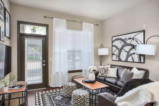 Leather couch with patterned ottomans and coffee table living room at 4050 Lofts in Tampa Student Accommodation