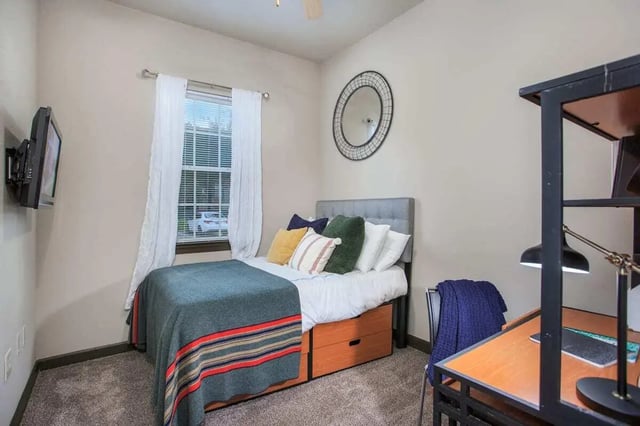 Bed with storage desk lamp and wall mounted TV bedroom at 4050 Lofts in Tampa Student Accommodation