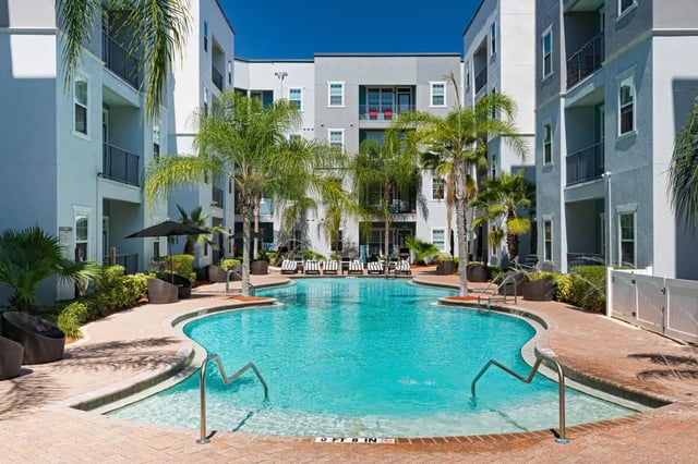 Pool loungers palm trees courtyard swimming pool exterior at 4050 Lofts in Tampa Student Accommodation