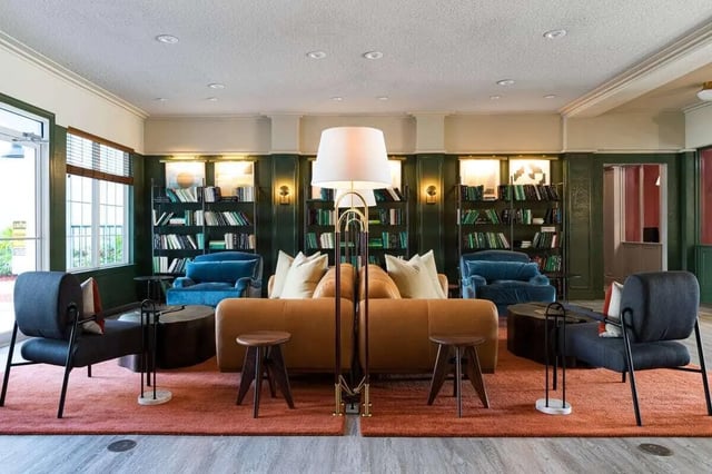 Sofa armchairs bookshelves and floor lamp living room at 4050 Lofts in Tampa Student Accommodation