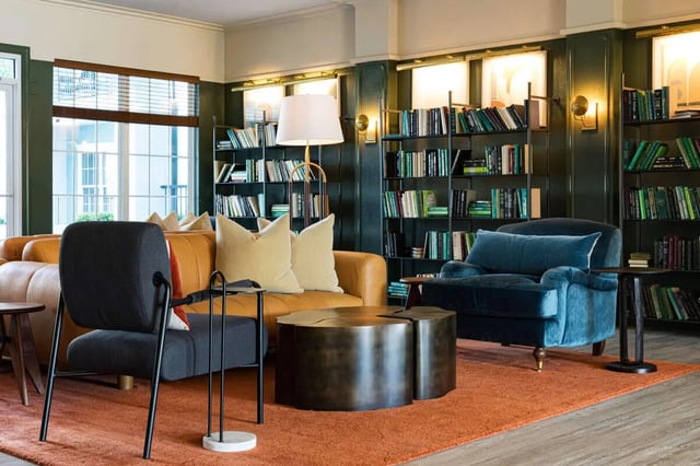 Sofa chair coffee table bookshelves living room at 4050 Lofts in Tampa Student Accommodation