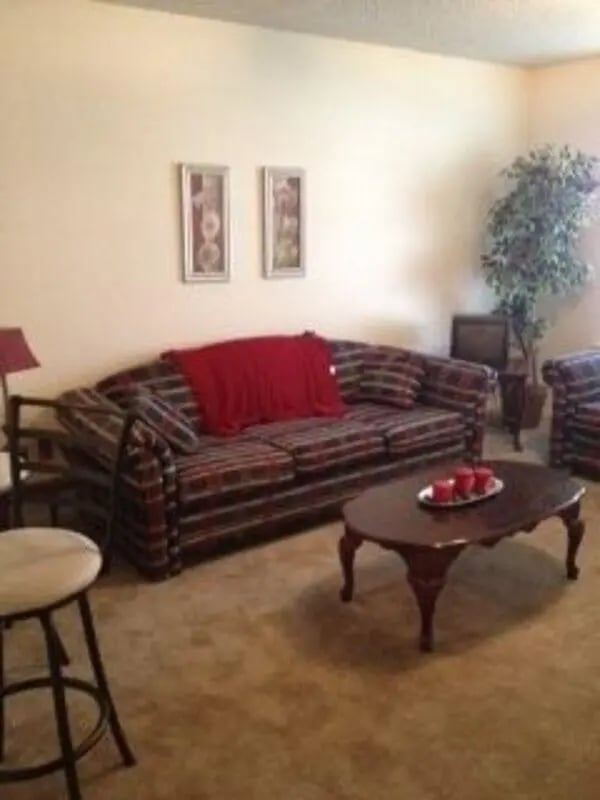 Sofa red throw oval coffee table pictures living room at Baylor Plaza III in Waco Student Accommodation