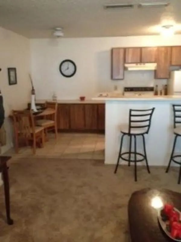 Clock chairs table kitchen living room at Baylor Plaza III in Waco Student Accommodation