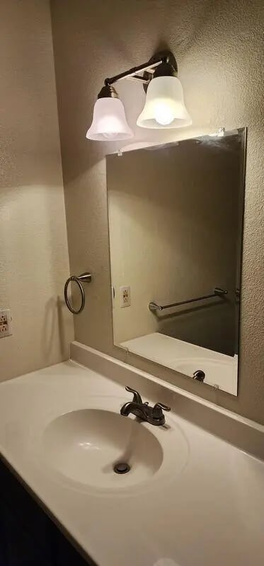 Sink vanity mirror towel rack and light fixture bathroom at Baylor Plaza III in Waco Student Accommodation