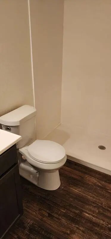 Toilet and shower area with dark floor Bathroom at Baylor Plaza III in Waco Student Accommodation