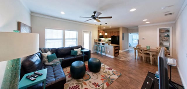 Dark sectional sofa teal pillows patterned rug living room at Archstone Luxury Apartments in Gainesville Student Accommodation