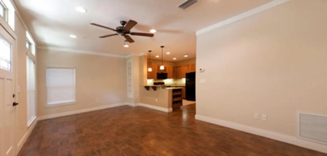 Ceiling fan kitchen cabinets and refrigerator living room at Archstone Luxury Apartments in Gainesville Student Accommodation