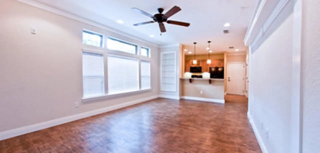 Living room with ceiling fan and open kitchen. at Archstone Luxury Apartments in Gainesville Student Accommodation