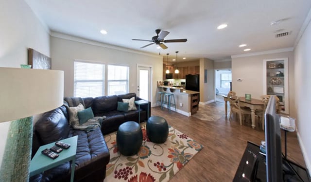 Leather sectional couch ottoman kitchen and dining area at Archstone Luxury Apartments in Gainesville Student Accommodation