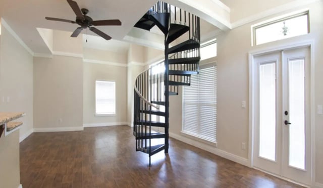 Spiral staircase ceiling fan double doors living room at Archstone Luxury Apartments in Gainesville Student Accommodation