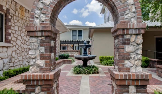 Stone archway fountain and courtyard exterior at Archstone Luxury Apartments in Gainesville Student Accommodation