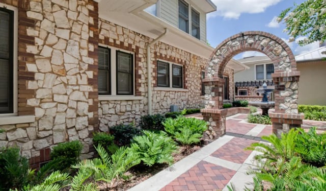 Stone facade brick archway paved walkway garden exterior at Archstone Luxury Apartments in Gainesville Student Accommodation
