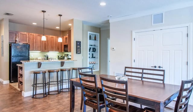 Kitchen island with stools and dining table living room at Archstone Luxury Apartments in Gainesville Student Accommodation