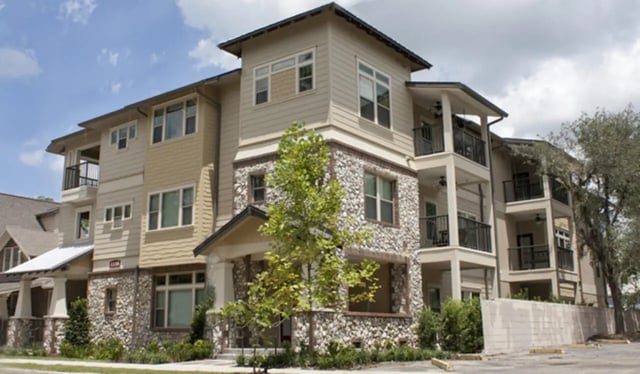 Stone and beige multi story building with balconies exterior at Archstone Luxury Apartments in Gainesville Student Accommodation