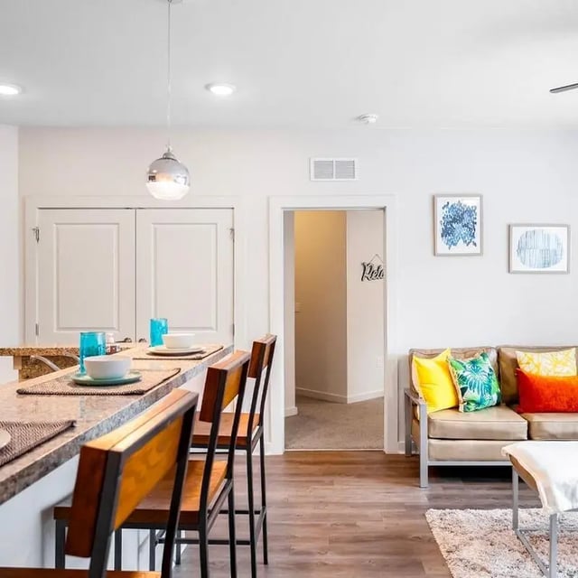 Bar stools and couch with pillows living room at Halo 46 Apartments in Tampa Student Accommodation