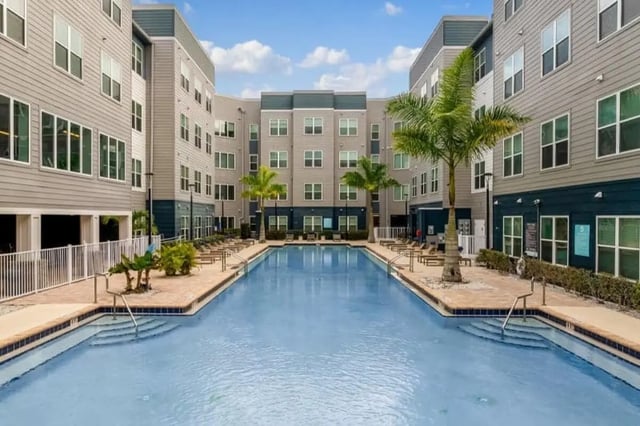 Apartment buildings surround a large swimming pool exterior at Halo 46 Apartments in Tampa Student Accommodation