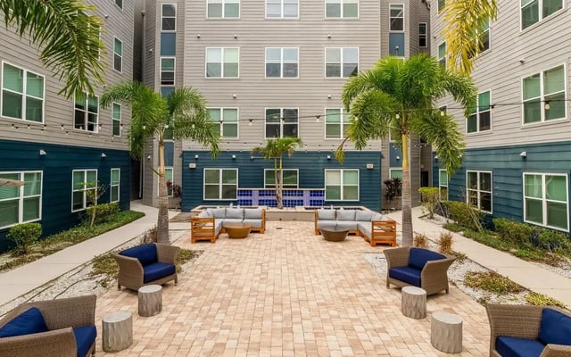 Courtyard seating area with palm trees and couches courtyard at Halo 46 Apartments in Tampa Student Accommodation