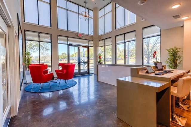 Red chairs reception desk computers plants lobby at Park Place Baton Rouge in Baton Rouge Student Accommodation