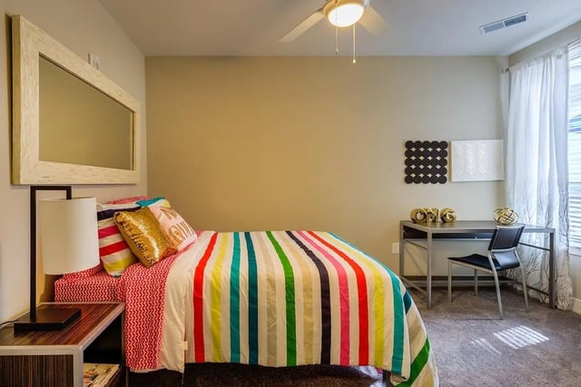 Bed with colorful striped duvet and desk bedroom at Park Place Baton Rouge in Baton Rouge Student Accommodation
