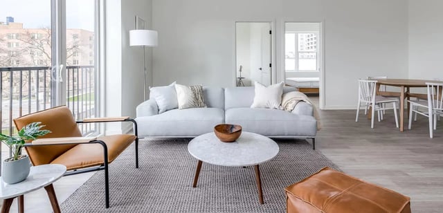 Light gray sofa, leather chair, dining table, living room at Addams Coliving in Chicago Student Accommodation