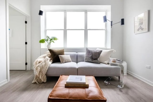 Gray sofa leather ottoman plant window living room at Addams Coliving in Chicago Student Accommodation