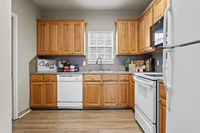 Wooden cabinets dishwasher sink and stove kitchen at Bear Crossing Apartments in Waco Student Accommodation