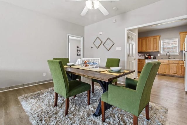Dining table with green chairs kitchen area dining room at Bear Crossing Apartments in Waco Student Accommodation