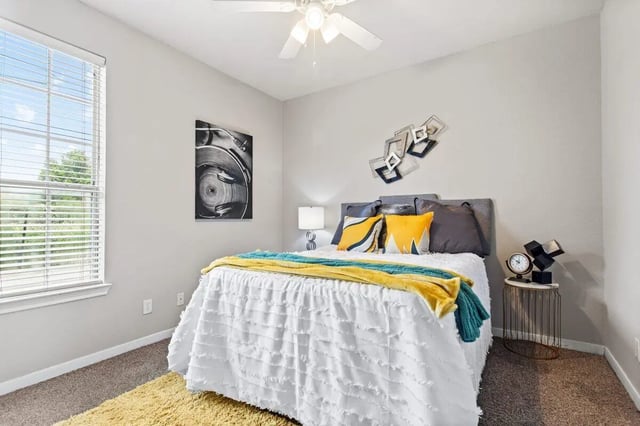 Bed with pillows throws artwork and lamp bedroom at Bear Crossing Apartments in Waco Student Accommodation