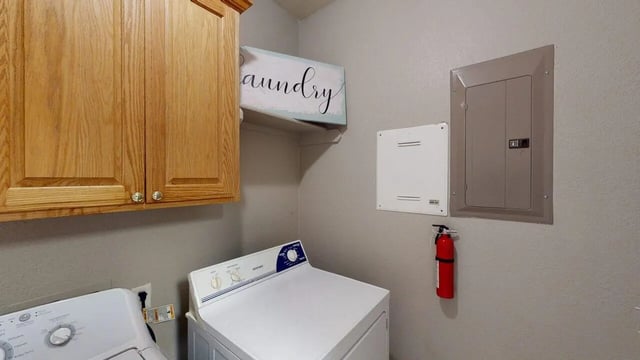 Cabinets washer dryer fire extinguisher laundry room at Bear Crossing Apartments in Waco Student Accommodation