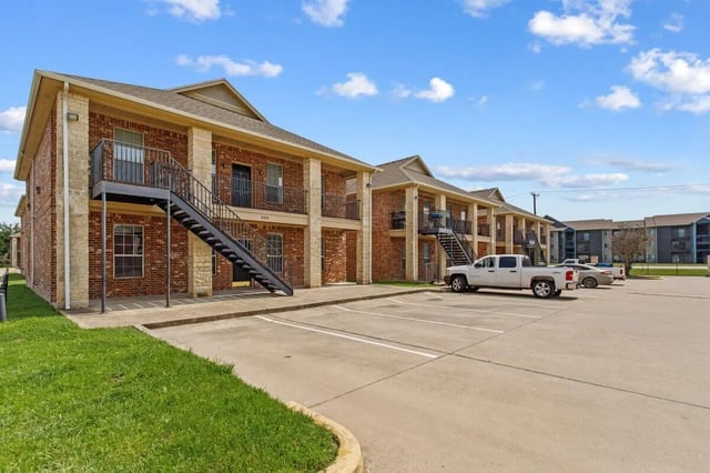 Brick apartment building with stairs exterior at Bear Crossing Apartments in Waco Student Accommodation