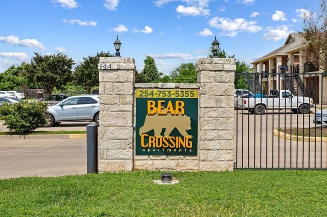 Stone gate sign with bear logo exterior at Bear Crossing Apartments in Waco Student Accommodation
