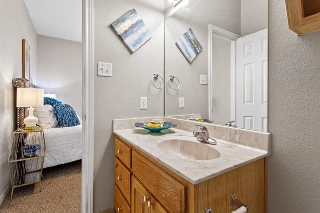 Sink vanity artwork and towels bathroom at Bear Crossing Apartments in Waco Student Accommodation