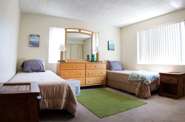 Two beds dresser mirror green rug bedroom at Collegiate Arms in State College Student Accommodation