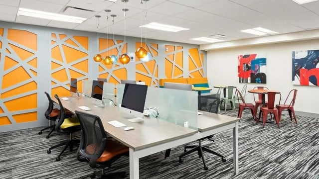 Desks computers chairs with orange accent wall study area at Varsity on K Apartments in Washington Student Accommodation