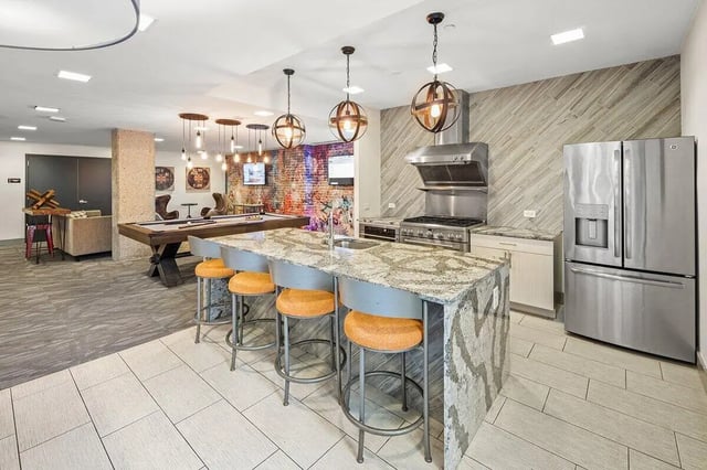 Kitchen island with stools pool table and seating area living room at Varsity on K Apartments in Washington Student Accommodation