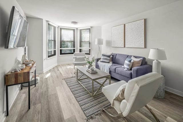 Sofa chairs coffee table and TV living room at Varsity on K Apartments in Washington Student Accommodation