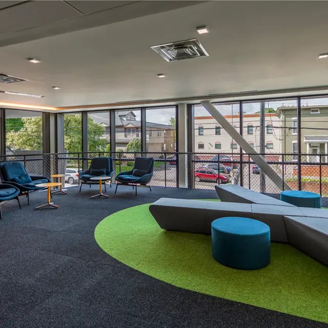 Modern seating area with blue chairs and lounge living room at 505 on Walnut Apartments in Syracuse Student Accommodation