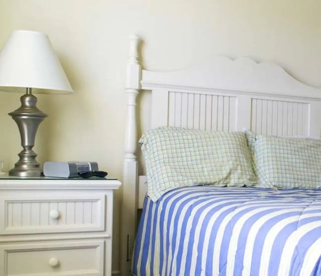 Lamp bedside table with clock and bed bedroom at The Estate on Third in Waco Student Accommodation