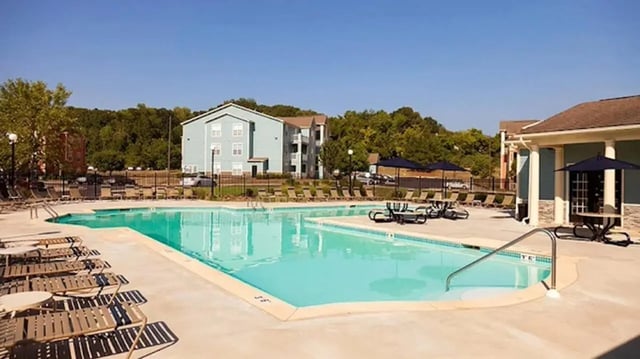 Pool lounge chairs umbrellas buildings exterior at Cape Trails in Cape Girardeau Student Accommodation