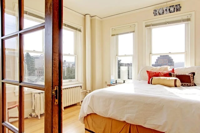 Wooden door to bed with pillows and windows bedroom at Commodore Duchess Apartments in Seattle Student Accommodation